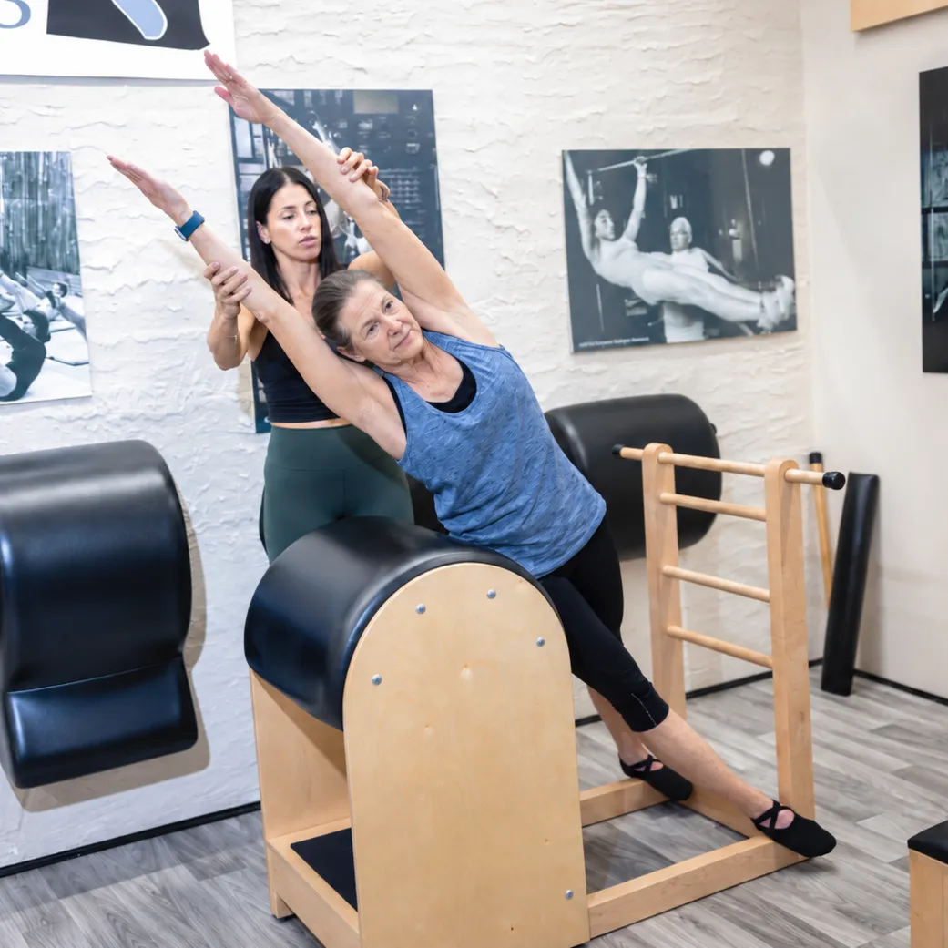 Woman in her 70s doing Pilates exercise on a ladder barrel during a private sessions at Evolution Pilates in Port Washington NY